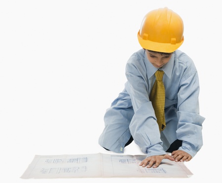 Boy dressed as an architect and working on a blueprintの写真素材