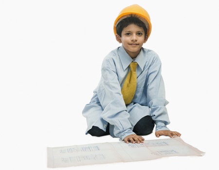 Boy dressed as an architect and working on a blueprintの写真素材