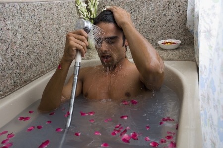 Man taking a shower in a bathtub