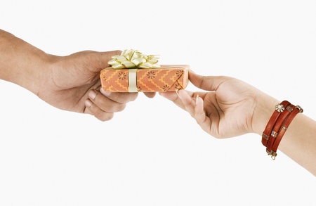 Man's hand giving a gift box to a woman