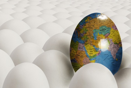 Egg with image of earth among plain white eggsの写真素材