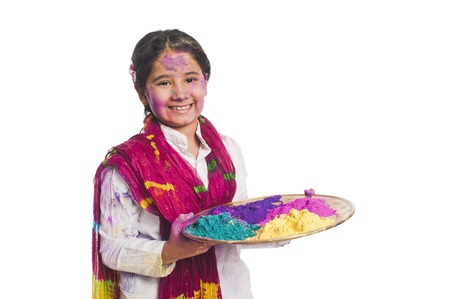Girl holding Holi colors in a plateの写真素材