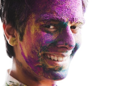 Mans face covered with powder paint during Holi festivalの写真素材