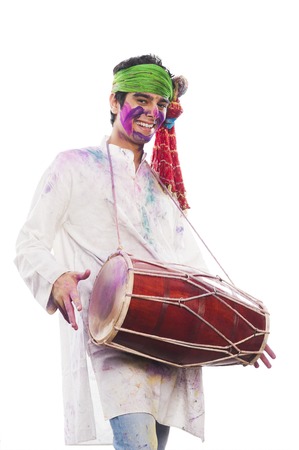 Man celebrating Holi with playing dholakの写真素材