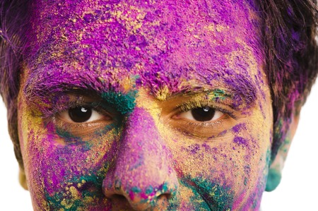 Mans face covered with powder paint during Holi festivalの写真素材