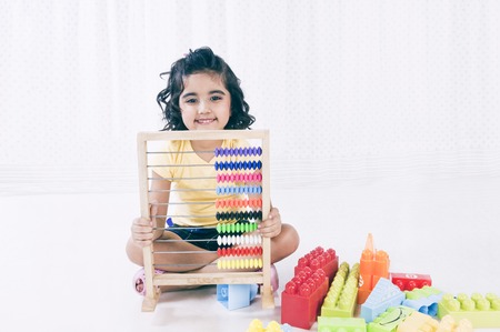Portrait of a girl playing with abacus and smiling
