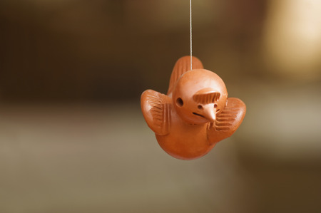 Close-up of a wooden little bird hanging by threadの写真素材