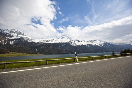 Road with snow covered mountains  in a valley, St. Moritz, Italyの写真素材