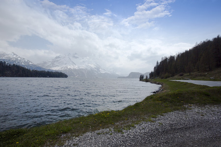 Lake with snow covered mountains  in a valley, St. Moritz, Italyの写真素材