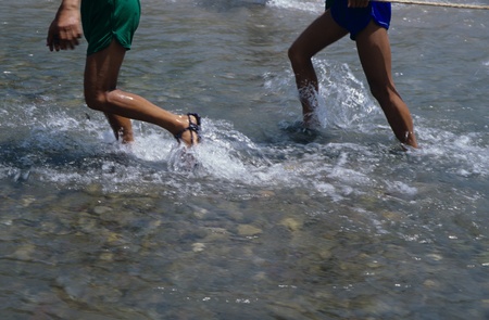 Low section of two people passing a riverのeditorial素材