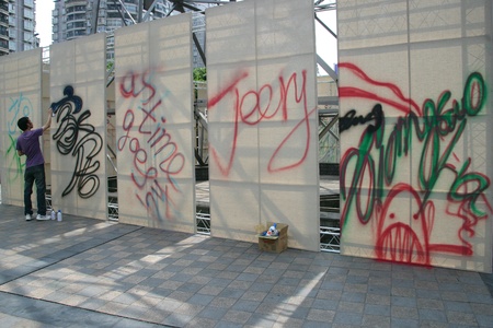 Man drawing graffiti on canvas in cityのeditorial素材