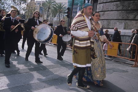 Men and women in traditional wear walking with street bandのeditorial素材
