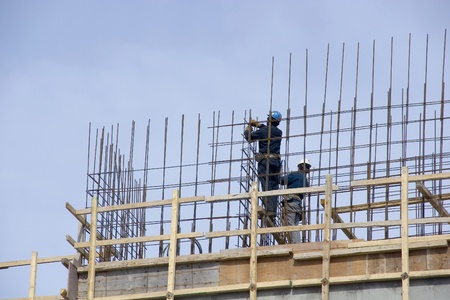 Construction workers securing rebar 