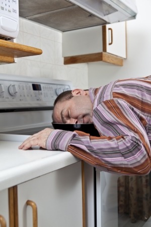 Exhausted man asleep in a frying pan の写真素材