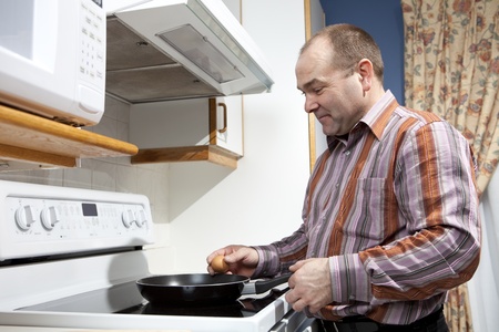 Man frying eggs の写真素材