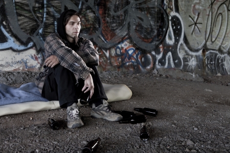 Homeless alcoholic drinking beer の写真素材