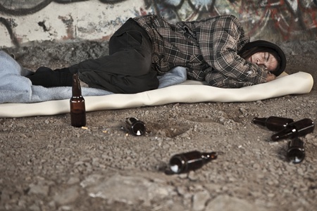 Homeless alcoholic sleeping outdoors の写真素材