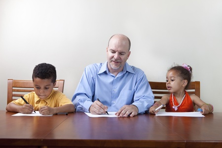 Single father helping kids with homeworkの写真素材