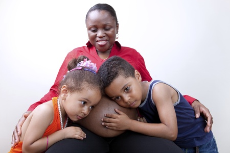 Kids listening to mom`s pregnant belly の写真素材