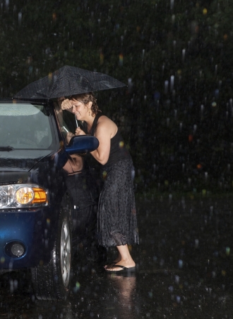 Woman locked out of her car in the rain の写真素材