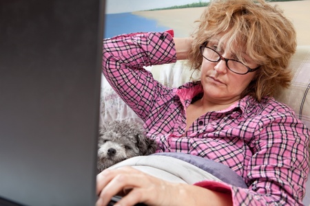Sick day, businesswoman working from home の写真素材