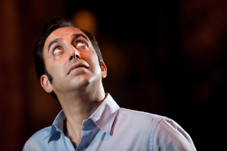 Low Key serious portrait of a man looking up 