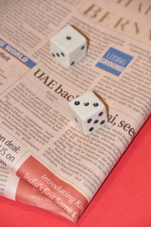 Dice resting on newspaperのeditorial素材