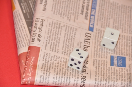Dice resting on newspaperのeditorial素材