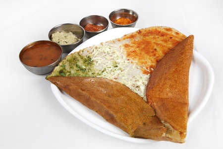 Dosa with chutney and sambar served in a plate