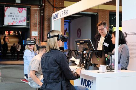 Berlin, Germany - May 3, 2018: Several visitors try Virtual Reality glasses at the WDR radio booth during the re:publica. re:publica is a conference about Web 2.0, weblogs, social media and the digital society.のeditorial素材
