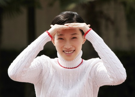 Girl shielding her eyes with her hands.