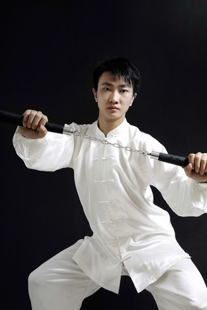 Man with nunchaku striking a pose for the camera