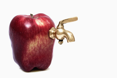 Red apple with faucetの写真素材