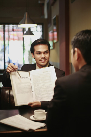 Businessman explaining contents of document to his clientの写真素材