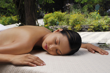 Woman lying forward on lounge chairの写真素材