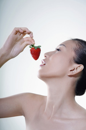 Woman about to eat strawberryの写真素材