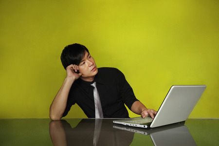 Businessman contemplating while using laptopの写真素材