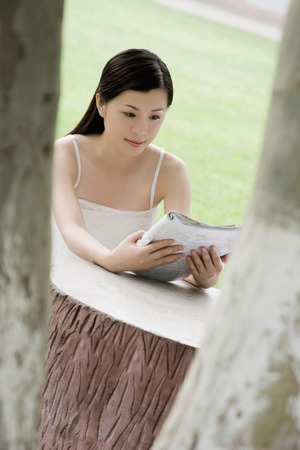 Woman reading book in the parkの写真素材