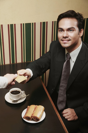 Businessman handing credit card to the waiterの写真素材