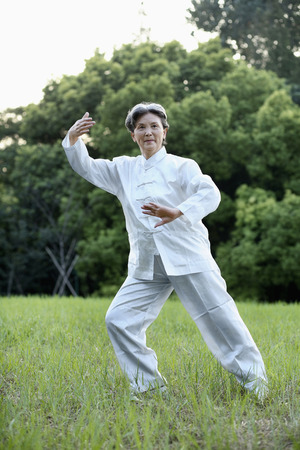 Woman practising Tai Chi in the parkの写真素材