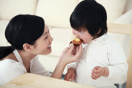 Woman feeding girl with muffinの写真素材