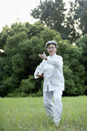 Woman practising Tai Chi in the parkの写真素材