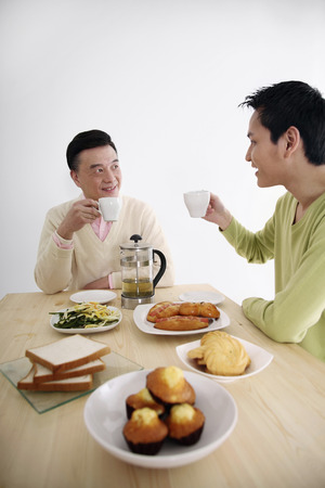 Man and senior man drinking tea togetherの写真素材