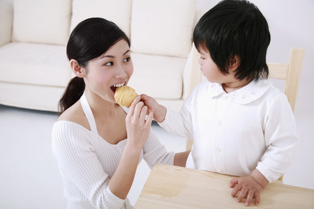 Girl feeding woman with cookieの写真素材
