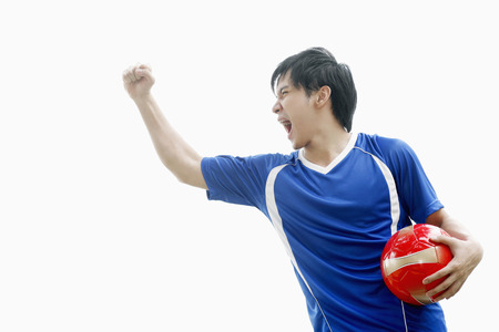 Man with soccer ball punching fist in the airの写真素材