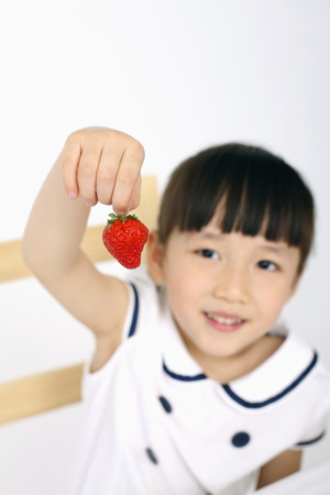 Girl holding strawberryの写真素材