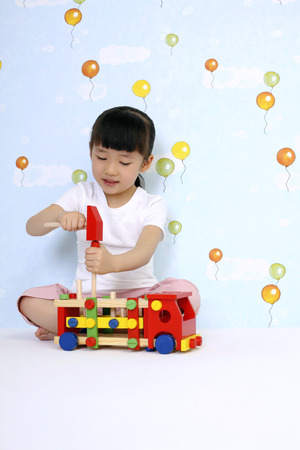 Girl playing wooden toy truckの写真素材