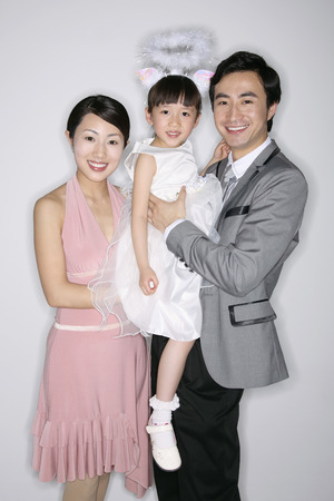 Man carrying girl with woman beside himの写真素材