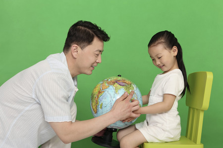 Man and girl looking at the globeの写真素材