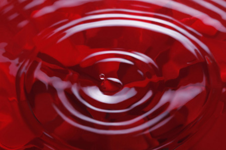 A drop of water falling into the waterの写真素材